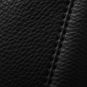 Close-up detail of leather jacket quality: full-grain texture and precise stitching indicating durability.